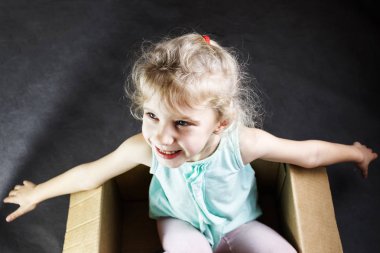 Llittle sarışın kız çığlıklar bir karton kutu içinde. Tonda.