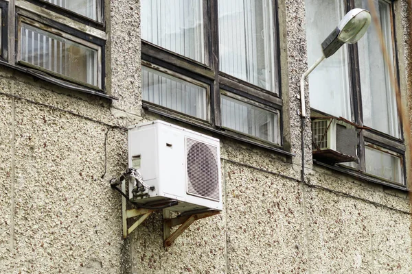 Air conditioning compressor. on the wall of an industrial building. located on the street.