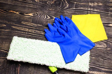 koyu ahşap arka plan, paspas ve eldiven. bir kazıyıcı gözlük ve temizlik ürünleri için vardır. tanirovanie olduğunu