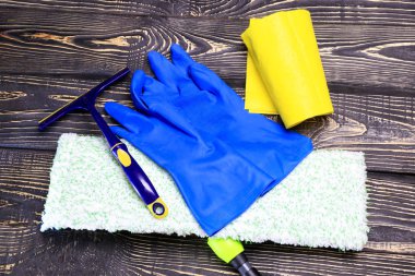 koyu ahşap arka plan, paspas ve eldiven. bir kazıyıcı gözlük ve temizlik ürünleri için vardır. tanirovanie olduğunu