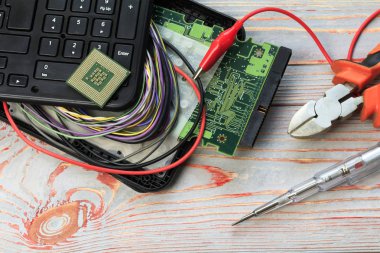 Kırık bir dizüstü bilgisayar ve bir tel üzerinde dışarı yapışmasını. Orada yan makas ve bir tornavida. onarım teknoloji kavramı. Orada tonlama