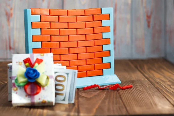 wall toys and red brick. near the gift box with cash dollars. have toning. The concept of buying real estate and you gift. discount or cash bonus,