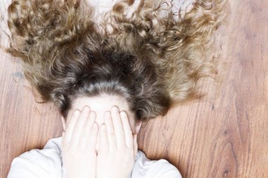 kız yüzünü elleri ile kaplı. makas var. Hasta saç veya yordamlar kullanımı için saç kesimi kavramı. Orada tonlama.