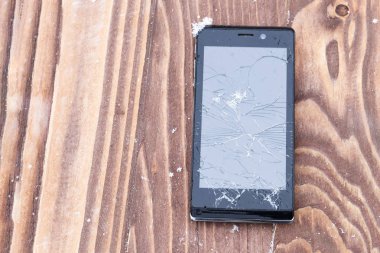 ahşap arka plan üzerinde kırık cep telefonu. Cep telefonu tamir. Orada tonlama.