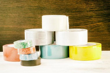 Birkaç rulo koli bandı yığılmış bir piramit. elektrik bandı yığını yakın dur. tonlama var. kesme sığ derinlik.