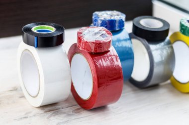 Birkaç rulo koli bandı. Ayağa kalk ve bize doğru rulo, elektrik bandıyla sarılır. tonlama var. kesme sığ derinlik