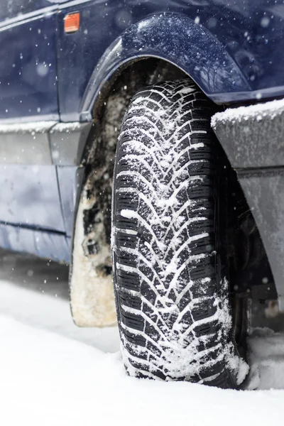 Winter is snowing. car wheel winter tires. close-up. have toning.