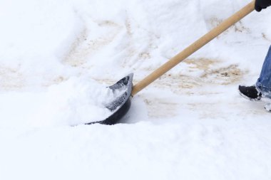 Kış kar çok. Genç bir kız, temizler, büyük kürek işi gurur.