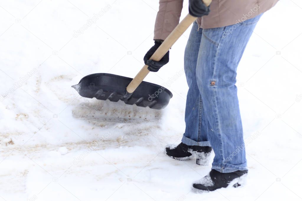 Winter is a lot of snow. A young girl, cleans, proud of doing the big shovel work.