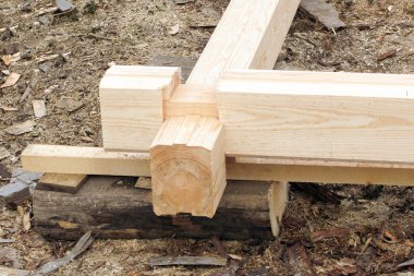 bir ahşap evin inşaat başlangıcı. Bar profilli bir ve oluk içine düşüyor. Köşede döşeme.