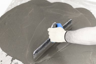 beton zemin. sinek üzerinde ufuk bile. yakın çekim. sıvı yere götürmek için çalışan bir spatula ile.