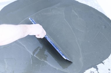 beton zemin. sinek üzerinde ufuk bile. yakın çekim. sıvı yere götürmek için çalışan bir spatula ile.