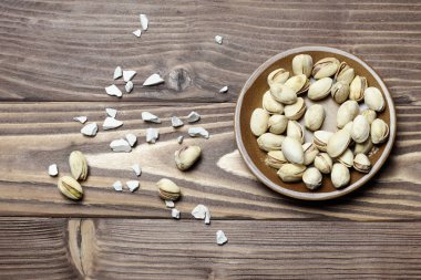 Kavrulmuş fıstık kil tabakta. eski ahşap arka plan.