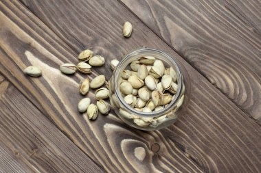 Kavrulmuş fıstık bir cam kavanoza. Eski ahşap arka plan. kesme sığ derinlik.