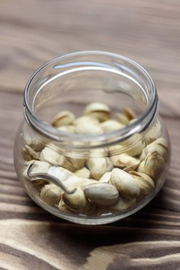 Kavrulmuş fıstık bir cam kavanoza. Eski ahşap arka plan. kesme sığ derinlik.