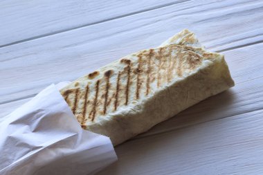 Kızın saç beyazdır. Shawarma yiyor. Fast food