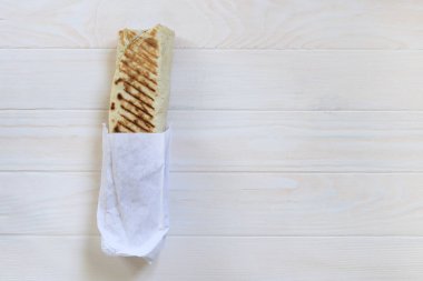 Kızın saç beyazdır. Shawarma yiyor. Fast food