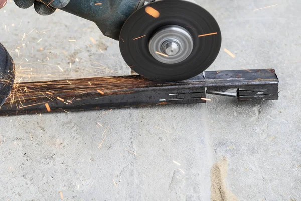 Master using grinders. a lot of sparks burn and work. cuts a square pipe. have toning. close-up — Stock Photo, Image