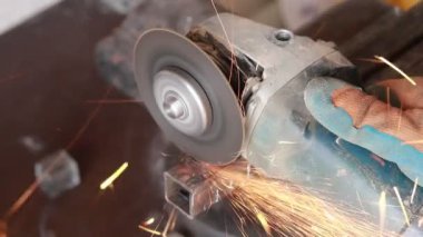 zımparalama makinesi. birçok sparks yakmak ve iş. kare boru keser. Tonlama var. yakın çekim