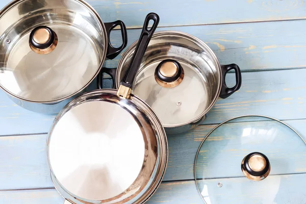 Ensemble de casseroles sur fond en bois. il y a un couvercle en verre . — Photo