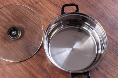 ahşap arka plan üzerinde bir tava. bir cam kapağı.