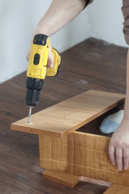 Sunta mobilya montaj işlemidir. Şarjlı tornavida vida sıkma için elinde.