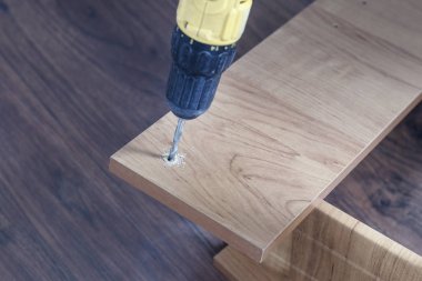 Sunta mobilya montaj işlemidir. Şarjlı tornavida vida sıkma için elinde.