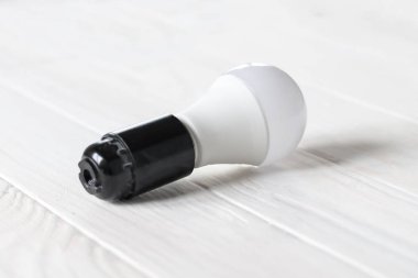 LED ışık karanlık bir Base. Ahşap bir arka plan üzerinde yatıyor. beyaz renk.