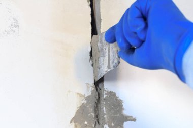 Teknik delik bir elektrik teli var. duvar beyazdır. Kablonun bir spatula ve harç ile Master kapsar