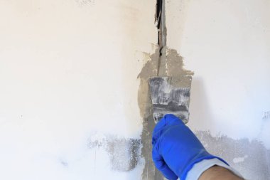 Teknik delik bir elektrik teli var. duvar beyazdır. Kablonun bir spatula ve harç ile Master kapsar