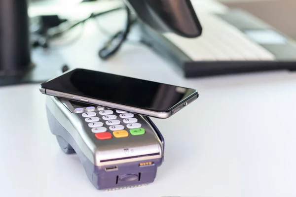 Acheteur, paiement par le terminal POS. téléphone portable comme une carte bancaire. il y a tonification — Photo