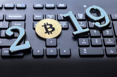 Altın bitcoin koyu renk klavye üzerinde yatıyor. Yazıt 2019. İşte bir tonlama