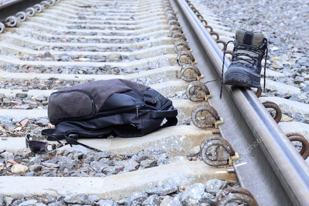 Railroad crossing. on it is a backpack, shoes, glasses. The concept of increased attention to the ways