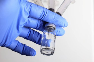 Doktor bir şişe boş tutar birkaç şırınga içine yerleştirilir. beyaz arka planda.