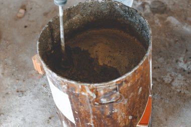 misafir işçi usta sıva için harç yoğurtu. metal kova. doğal bir süreçtir. tonlama var.