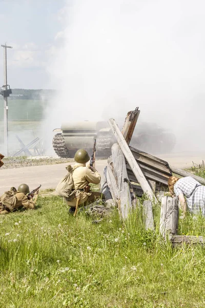 Dramatização. soldado de grande guerra patriótica segurando uma espingarda. Muita fumaça. há civis. . — Fotografia de Stock