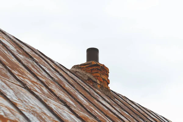 Techo de metal, la pintura casi desapareció. en su chimenea. trompeta y kerpich . —  Fotos de Stock