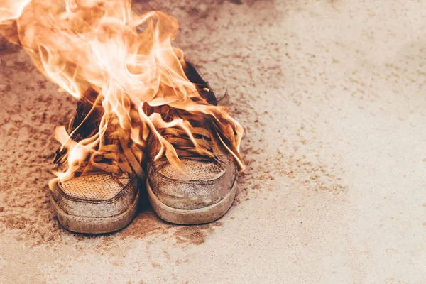 Areia de praia. As sapatilhas são muito velhas, queimando sob o fogo aberto. conceito é hora de comprar um novo par de sapatos . — Fotografia de Stock