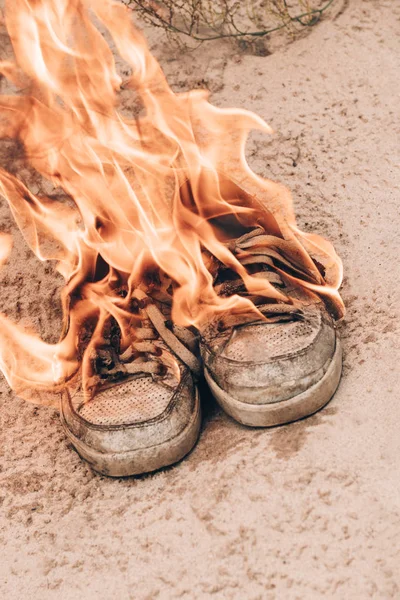 Sabbia della spiaggia. Le scarpe da ginnastica sono molto vecchie bruciano il fuoco aperto. hanno tonificante — Foto Stock