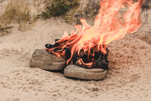 Arena de playa. Las zapatillas son muy viejas queman fuego abierto. tener tonificación —  Fotos de Stock
