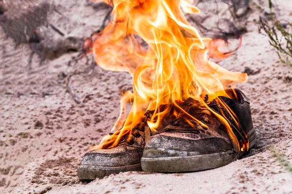 Sabbia della spiaggia. Le scarpe da ginnastica sono molto vecchie bruciano il fuoco aperto. hanno tonificante — Foto Stock