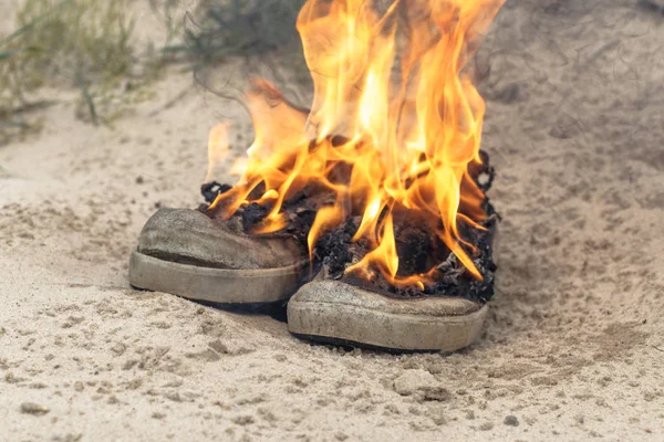 Arena de playa. Las zapatillas son muy viejas queman fuego abierto. tener tonificación —  Fotos de Stock