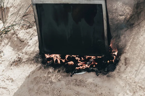 Arena de playa. sol brillante. el monitor se quema con humo. tener un teclado . —  Fotos de Stock