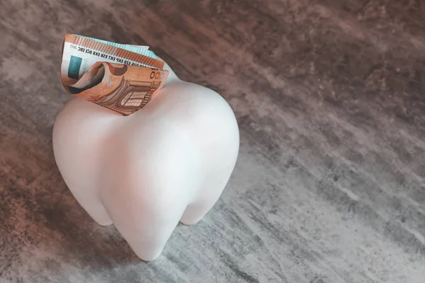 Großen Zahn in Form eines Sparschweins. Es hat den Euro. Bezahlte Zahnmedizin. — Stockfoto