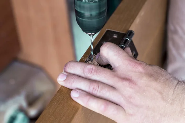 The master sets the door hinge. drills a hole with a tool — Stock Photo, Image