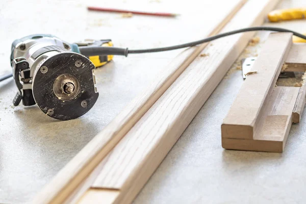 Installing a door, Install a door lock, use a milling saw, a carpenter close-up holds a green electric drill — Stock Photo, Image