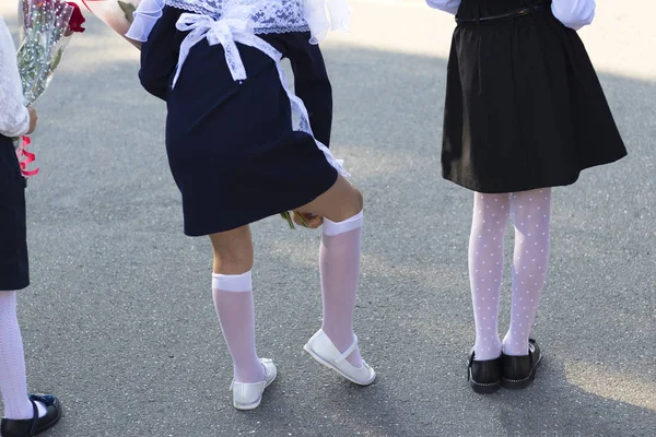 Setembro. início do ano letivo. vista para trás. menina endireita meias brancas . — Fotografia de Stock