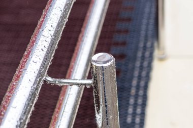 Sokak lambası. Yağmur yağıyor. Su damlalarında metal perryl