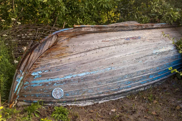 Luz do dia. barco azul é virado de cabeça para baixo. pintura desbotada ao sol . — Fotografia de Stock