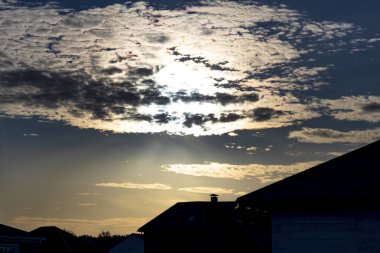 Gün ışığı. Gün batımı. Sonbahar. Güneş bulutlara yansıyor. tina evleri
